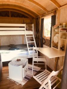 MountshannonRelax in the unique and cosy Off-grid Eco Shepherd's hut Between Heaven and Earth的客房设有双层床、桌子和书桌。