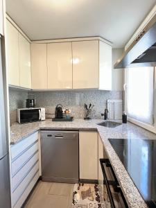 尼斯DIEGO 4 pièces duplex的厨房配有白色橱柜和微波炉