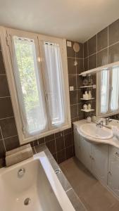 尼斯DIEGO 4 pièces duplex的带浴缸、水槽和镜子的浴室