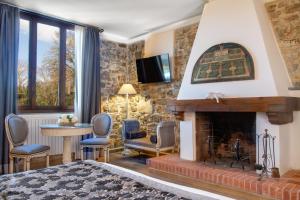 毕威格利亚努Residenza le Colline del Paradiso的客厅设有壁炉和电视。