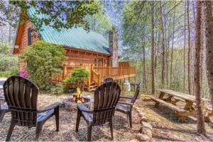 赛维尔维尔Lazy Bear Cabin的小屋前设有两把椅子和一个火坑