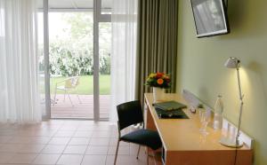 Lobbach曼弗雷德 - 绍尔基金会研讨会酒店的客房设有桌椅和滑动玻璃门