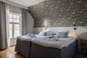 维斯比索尔姆贝斯特韦斯特酒店的一间卧室配有一张带花卉壁纸的大床