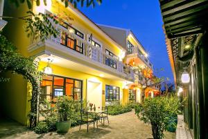 会安Hoi An Town Home Resort的前面有一张桌子的黄色建筑