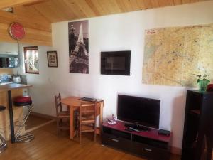 GagnyNormandy cottage的客厅配有桌子、电视和地图