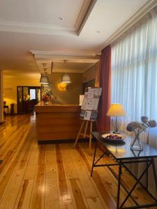 纳瓦塞拉达Hotel Rural Spa & Wellness Hacienda Los Robles的客厅铺有木地板,配有桌子