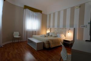 墨西拿Hotel Sant'Elia的一间卧室配有一张带条纹墙的床