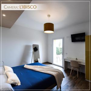 San FilippoCasale Ermo Colle的一间卧室配有蓝色的床、一张书桌和一个窗户。
