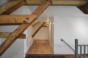 Mont-Notre-DameBel appartement 2 chambres climatisé的阁楼间设有木梁和白色墙壁。