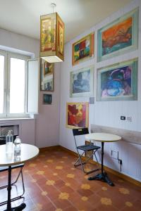 罗马罗马客房酒店的一间房间,墙上挂着两张桌子和绘画作品