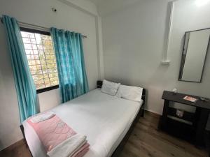 西里古里Marigold Hotel的一间小卧室,配有床和窗户
