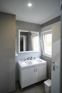 大戈里察Apartments Choice的浴室设有白色水槽和镜子
