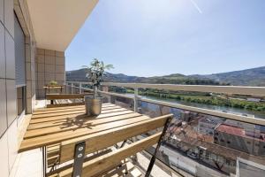比索达雷加Casa da Tia Douro的阳台配有木桌,享有河景