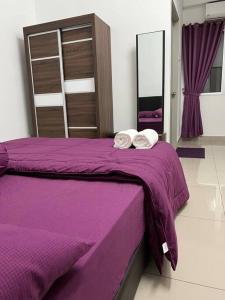 实兆远92D’venus Residence的紫色的床,上面有两条毛巾
