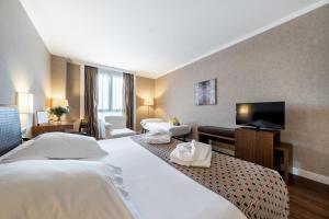 奥尔梅多Castilla Termal Olmedo的酒店客房设有两张床和一台平面电视。