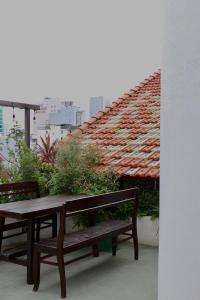 岘港Nhà bình Homestay的屋顶阳台的桌子和长凳