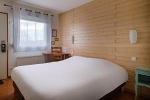 维特里勒弗朗索瓦Eqynox Hotel的卧室配有白色的床和木墙