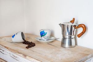 滨海波利尼亚诺Respiro del mare的一张带两个杯子的木桌和茶壶