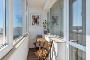瓦尔纳Cosy apartment in central Varna的阳台配有两把椅子和两扇窗户