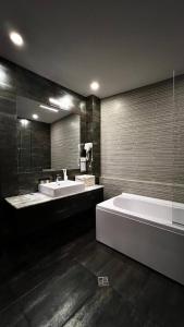 第比利斯Marmenio Hotel - Tbilisi的大型浴室设有两个盥洗盆和浴缸。