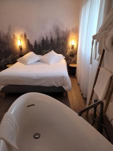 Vieille-BrioudeMaison Les Glycines的一间卧室配有一张床,床边配有浴缸