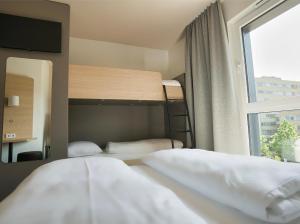 科隆B&B Hotel Köln-City的一间卧室设有两张双层床和一扇窗户。