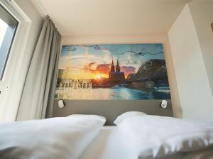 科隆B&B Hotel Köln-City的一间卧室设有两张床,墙上挂着一幅画