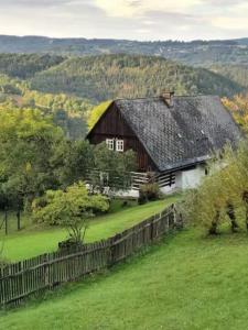KoberovyStylový vesnický apartmán v soukromí M. Skála Český Ráj的田野上带黑色屋顶的谷仓