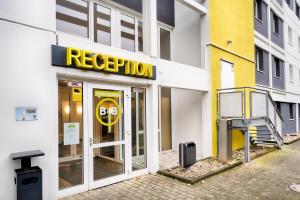 弗雷兴B&B HOTEL Köln-Frechen的建筑的外墙,有黄色疏散标志
