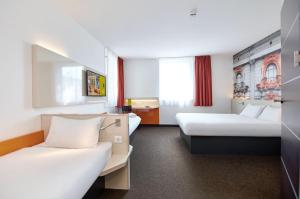 罗兹罗兹市中心B&B酒店的酒店客房,设有两张床和一张沙发
