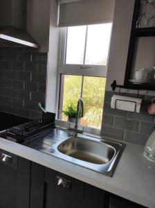利敦瓦纳Apartments at Ballinsheen House & Gardens的厨房设有水槽和窗户。