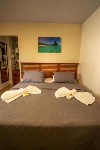 费尔南多 - 迪诺罗尼亚Pousada Flôr do Atlântico的一间卧室配有两张带毛巾的床