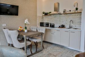 阿基欧斯尼古拉斯Beach Walk Luxury Suites的厨房配有桌椅和水槽。