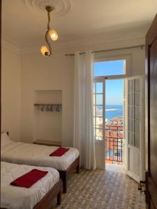 阿尔及尔AFRIC HOTEL- Casbah的一间卧室设有两张床和大窗户