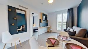 圣莫里斯City Résidence Paris Saint-Maurice的客厅配有沙发和桌椅