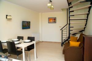 弗瓦迪斯瓦沃沃Family Homes - Sand Apartments的一间带桌子和螺旋楼梯的用餐室
