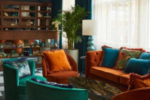 埃克塞特Hotel Indigo - Exeter, an IHG Hotel的客厅配有橙色和蓝色的椅子和桌子
