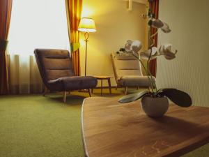 苏恰瓦雷斯登斯酒店的一间房间,里面摆放着两把椅子和一张桌子,上面有植物