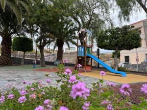 圣米格尔德阿沃纳Casa rosa的鲜花公园内一个带滑梯的游乐场