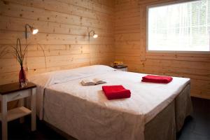 米凯利Villa Valmuska的一间卧室配有一张带两个红色毛巾的床