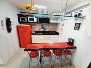若昂佩索阿Cabo Branco Dream的厨房配有红色台面和红色凳子
