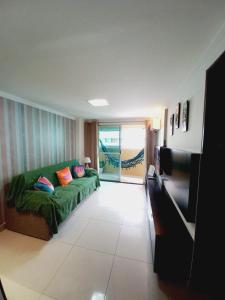 若昂佩索阿Cabo Branco Dream的客厅设有绿色沙发和滑动玻璃门