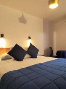 安托法加斯塔Hostal valle de la luna的一间卧室配有一张大床和两个枕头