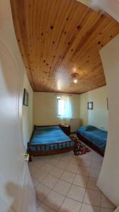费内斯Peak heaven的一间卧室设有两张床和木制天花板