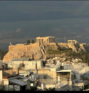 雅典kolonaki Penthouse panoramic Acropolis view的山丘上一座建筑的城市景观