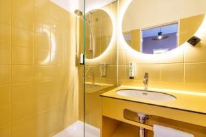 沙恩Kloster by b-smart的黄色的浴室设有水槽和镜子