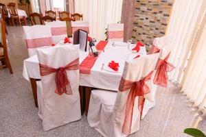 多布拉沃达MS Hotel的一张带白色椅子和红色弓的桌子