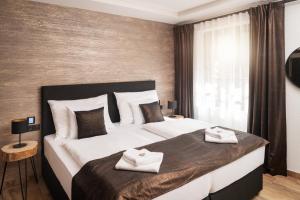 比拉Wellness Hotel Ondrášův dvůr的一间卧室配有一张大床和两条毛巾
