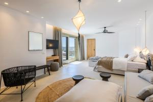 米克诺斯城Nasta Suites & Villas Intentional Living Mykonos的一间卧室配有一张床、一张沙发和一张桌子