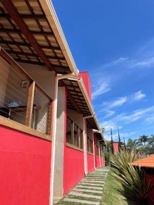 布鲁马迪纽Pousada Verde Villas的一座红色的建筑,有楼梯通往